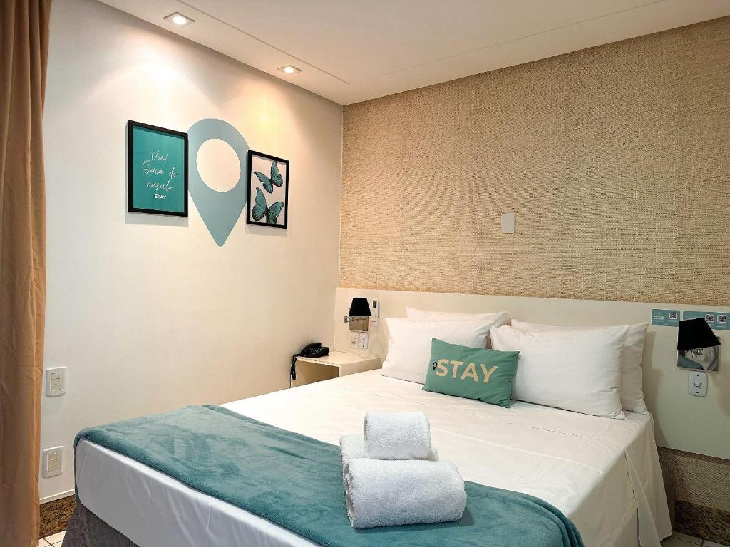 戈亚尼亚STAY Sun Square的一间卧室配有一张带绿色和白色枕头的床