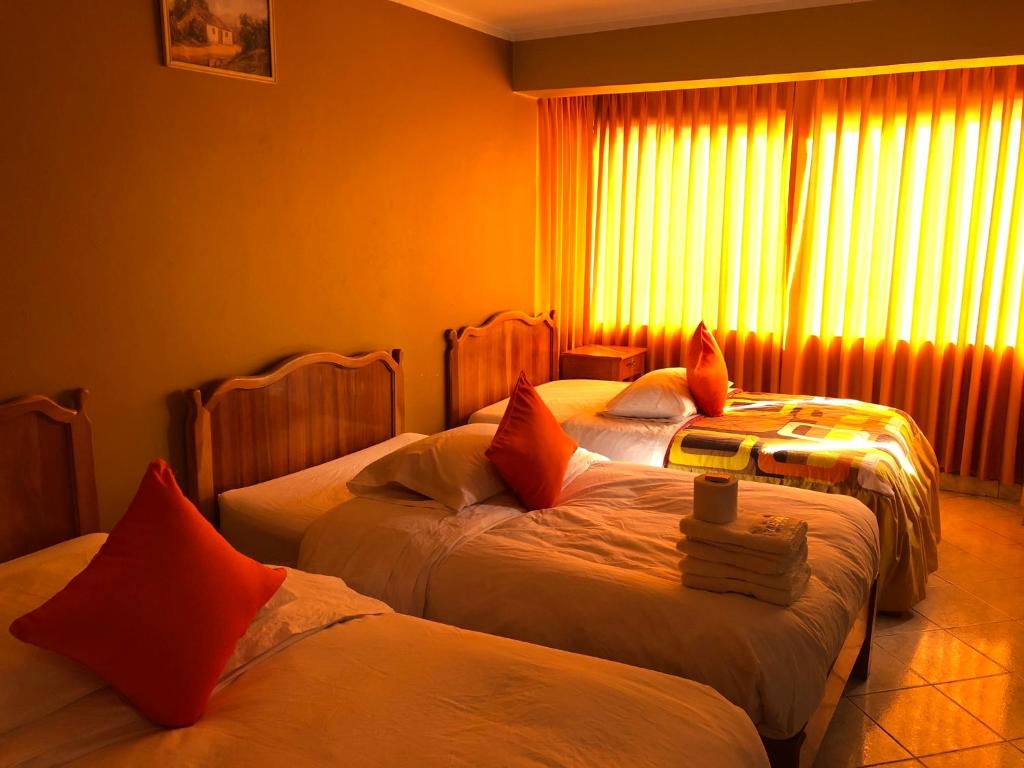 阿亚库乔Prince Hospedaje的酒店客房设有两张床和窗户。