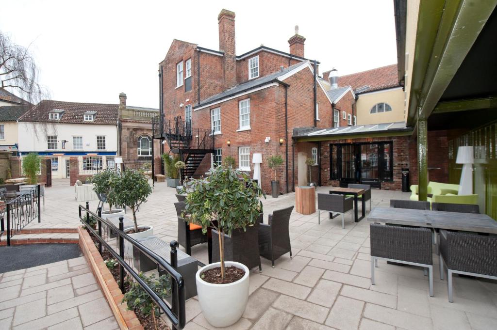 贝克尔斯The King's Head Hotel Wetherspoon的一座配有桌椅的庭院和一座建筑