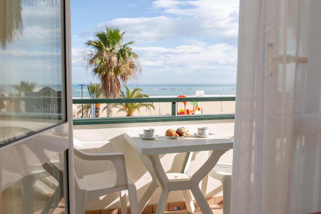 阿布鲁齐的罗塞托Hotel Roma Sul Mare的一张桌子和椅子,享有海滩美景