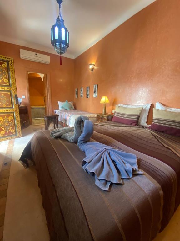 马拉喀什Riad Dar Teranga Hotel & Spa的一间卧室配有两张床和吊灯。