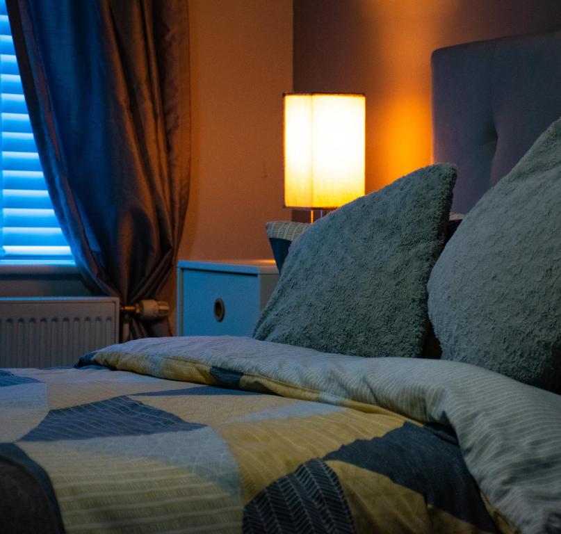 马斯顿格林Cosy Modern Flat (NEC/BHX Stays)的一间卧室配有带枕头和台灯的床