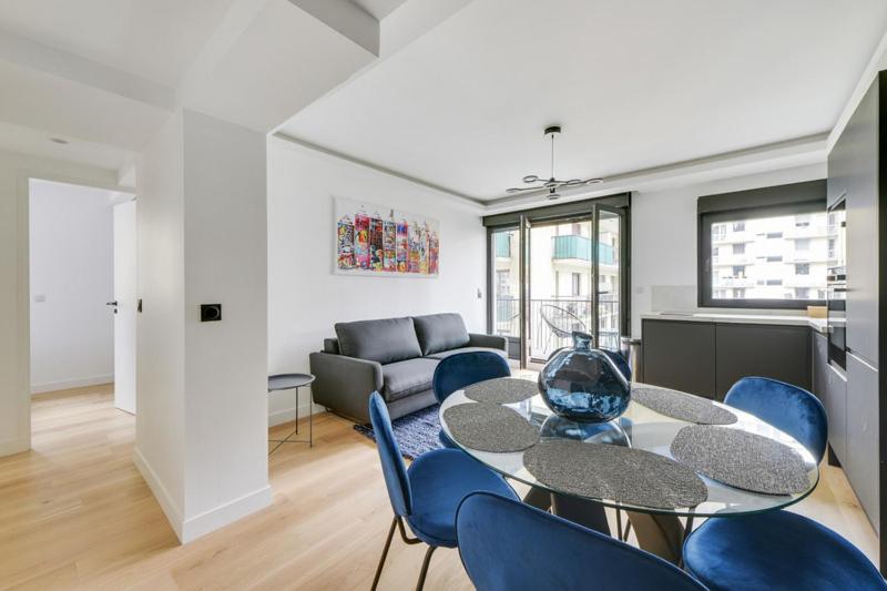 巴黎181 One Suite - Superb apartment in Paris.的客厅配有桌子和蓝色椅子
