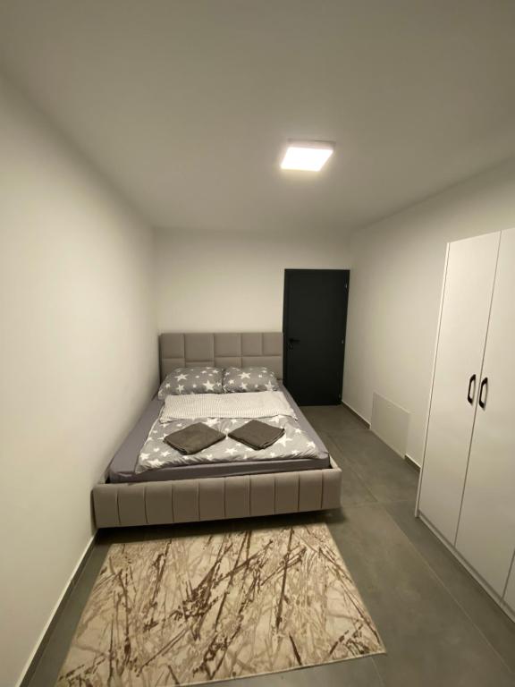 乌罗舍瓦茨Luxos Villa的卧室配有一张床,地板上铺有地毯