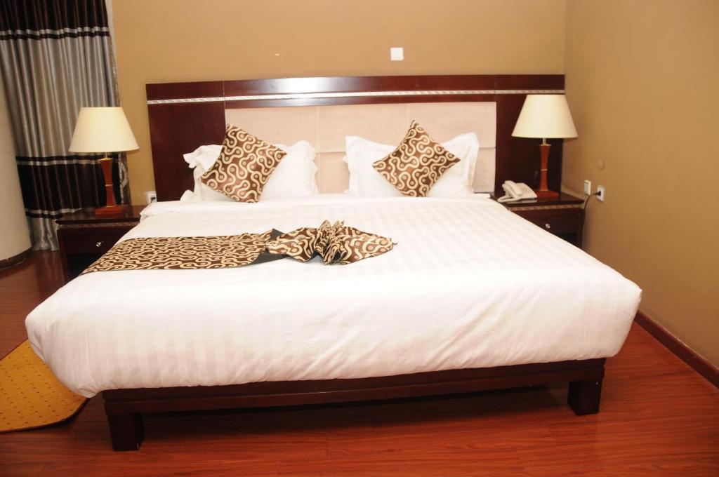 亚的斯亚贝巴Melka International Hotel的卧室配有带豹枕头的大型白色床