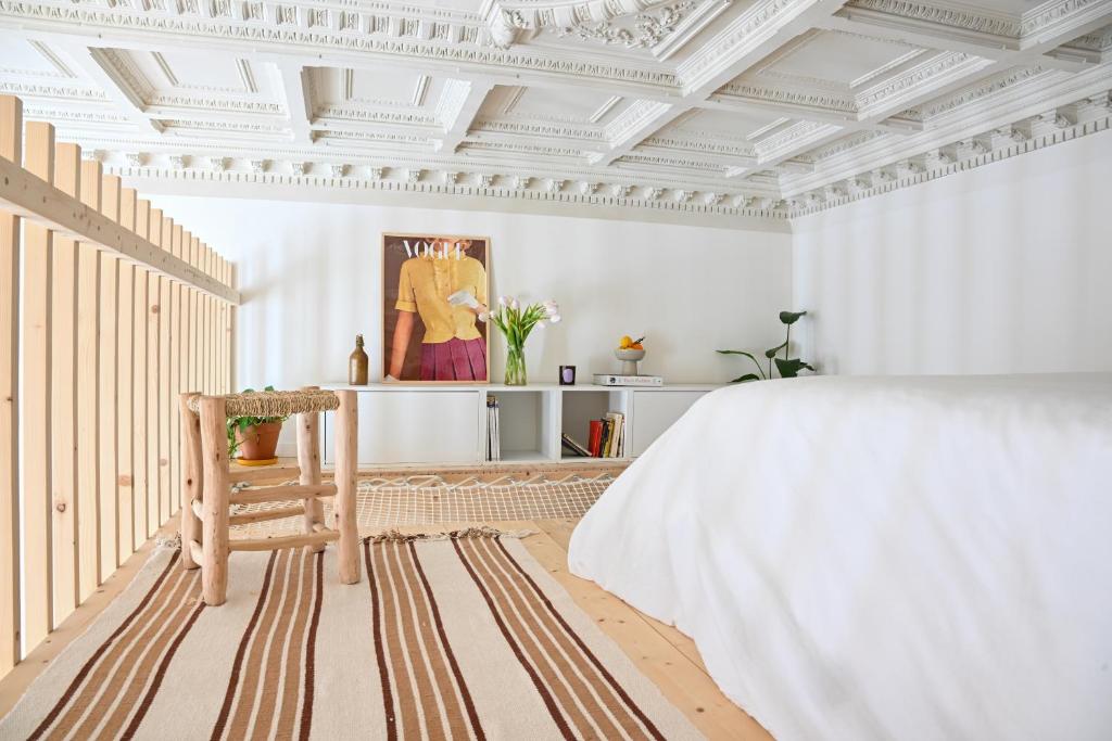 波尔多Appartement gare Saint jean的卧室设有白色天花板、一张床和一把椅子
