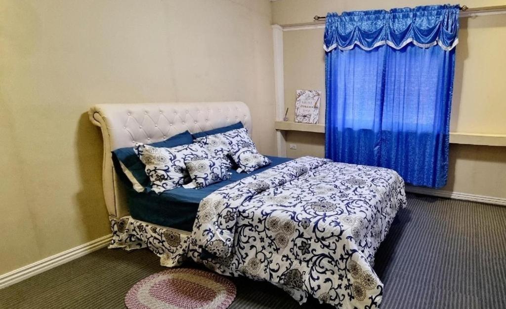 利安Omma's Beach house的一间卧室配有一张蓝色窗帘的床