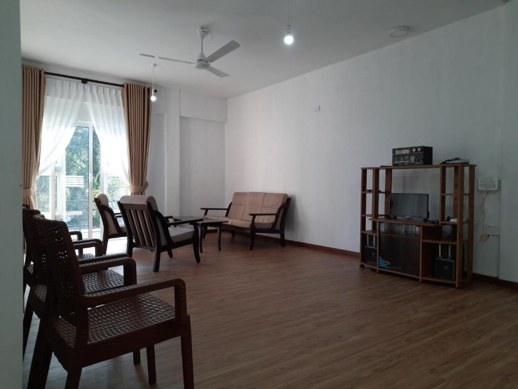 KundasaleHEATHER NEST HOMESTAY - KUNDASALE的客厅配有椅子、桌子和沙发