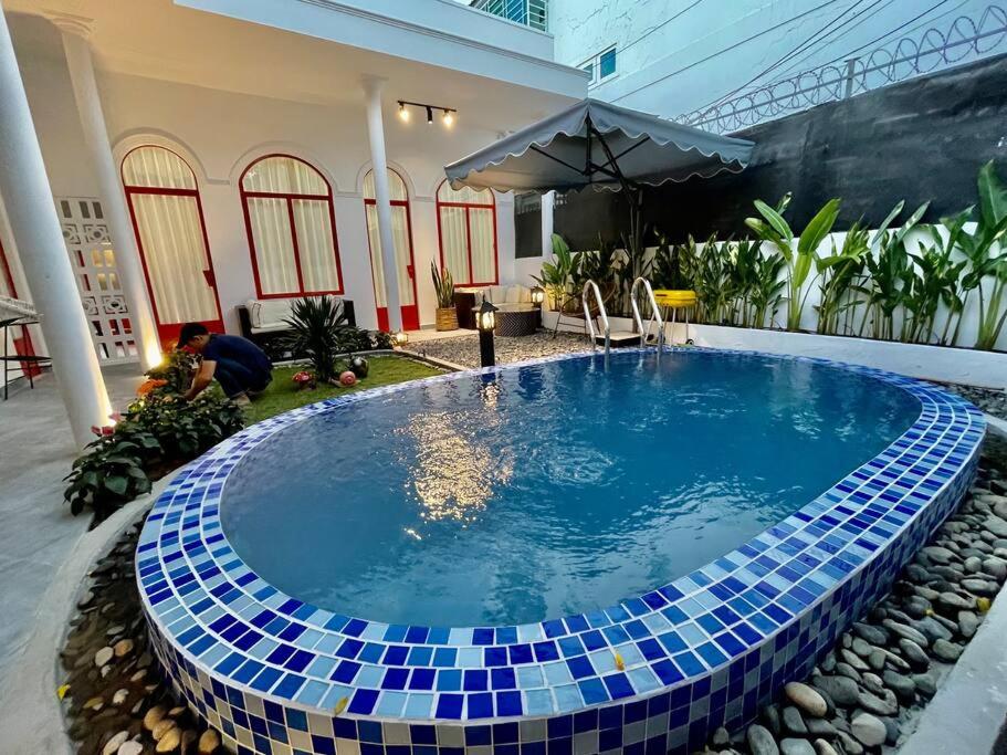 芽庄Holi Dolce Vita Pool Villa的一座环绕着房子的蓝色瓷砖游泳池