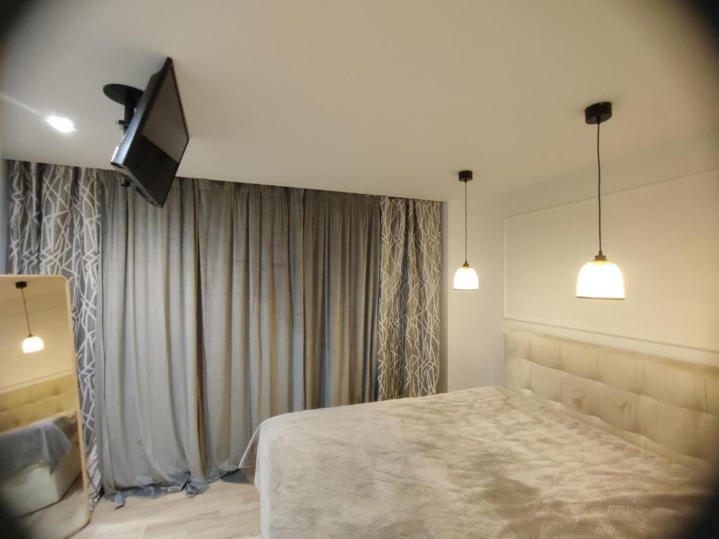 罗兹DWUPOKOJOWY APARTAMENT 51 m2的一间卧室配有一张床和一台平面电视