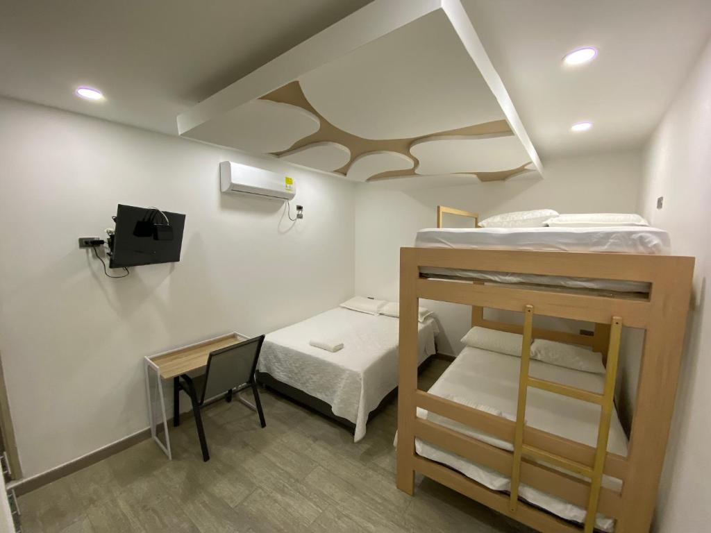 CurumaníHotel Dubai Deluxe Curumani的小房间设有两张双层床和一张书桌