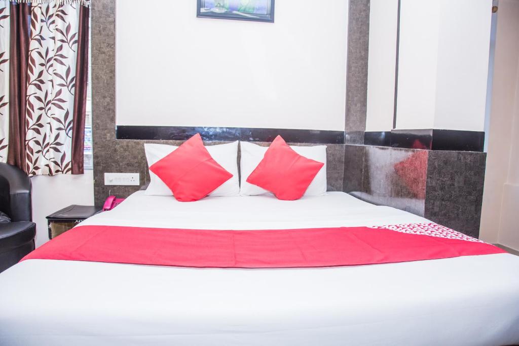 阿加尔塔拉OYO Hotel Executive Inn的一间卧室配有一张带红色枕头的大床