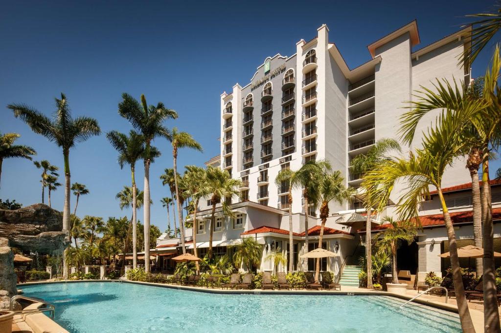 劳德代尔堡Embassy Suites by Hilton Fort Lauderdale 17th Street的一座拥有游泳池和棕榈树的酒店