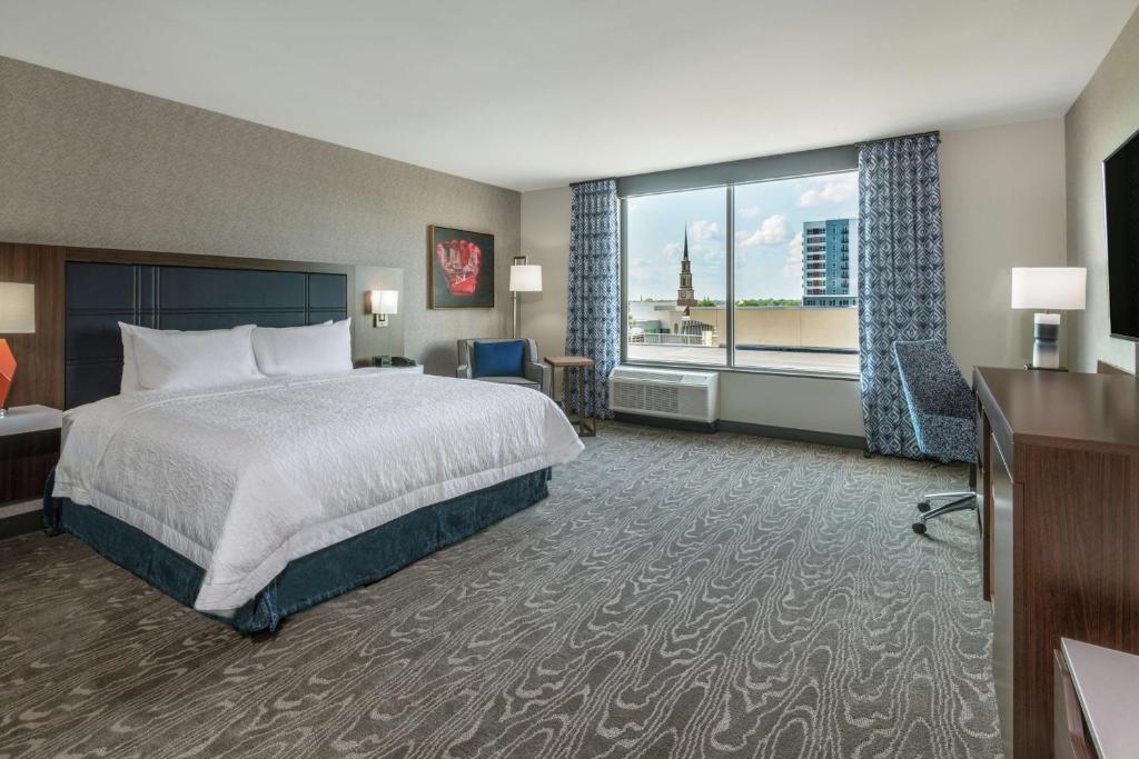 韦恩堡Hampton Inn & Suites Fort Wayne Downtown的酒店客房设有一张床和一个大窗户