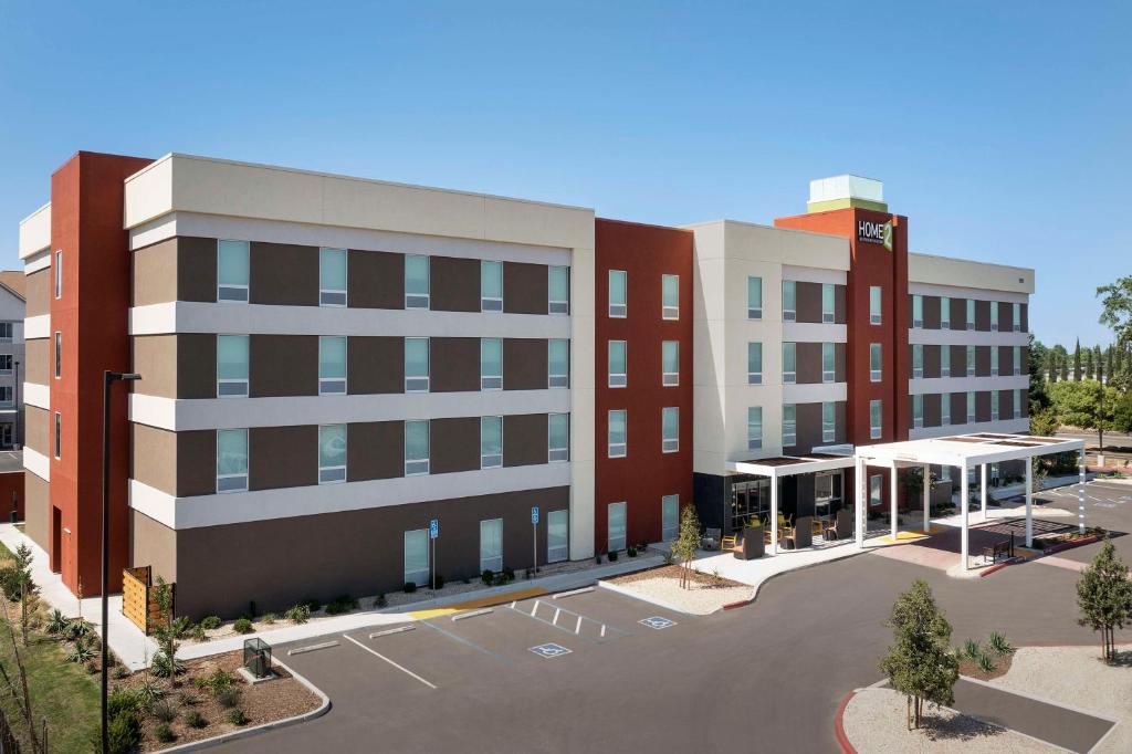 克洛维斯Home2 Suites By Hilton Clovis Fresno Airport的享有带停车场的大楼的顶部景色