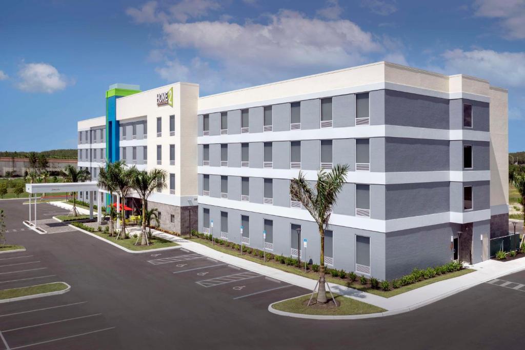 迈尔斯堡Home2 Suites by Hilton Fort Myers Airport的一张带停车场的办公楼的照片