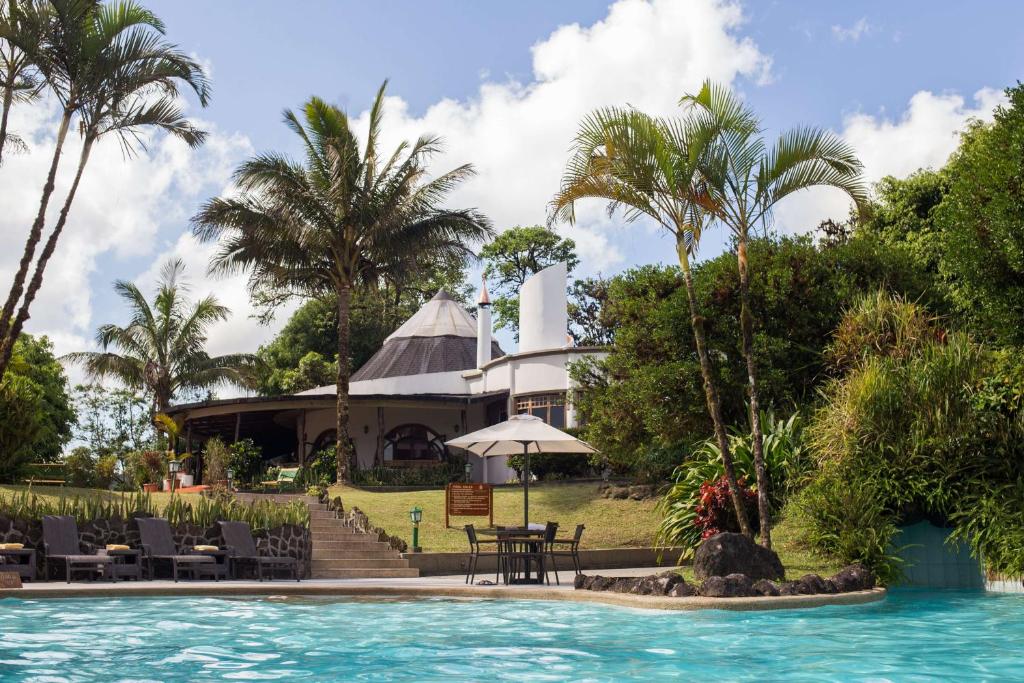 BellavistaRoyal Palm Galapagos, Curio Collection Hotel by Hilton的一个带游泳池和大楼的度假胜地