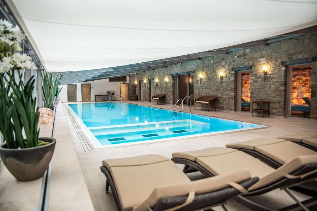 艾珍明希豪森城堡酒店的周围设有大型游泳池,配有椅子