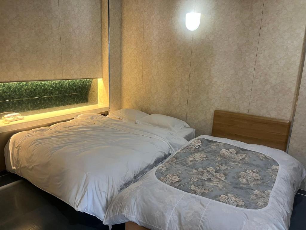 大洲Higashi Kumamoto Business Center的一间小卧室,配有两张床和窗户