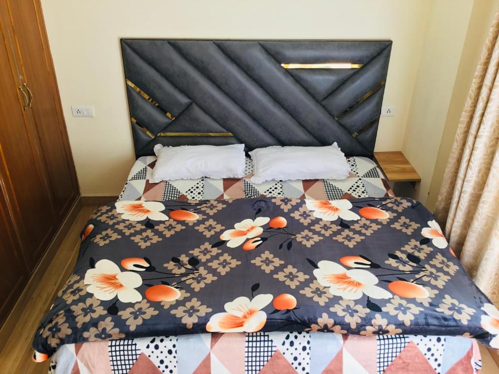 西姆拉Shimla Vibes B & B free pick & drop from ISBT Shimla的一张带黑色床头板的床上,上面有鲜花