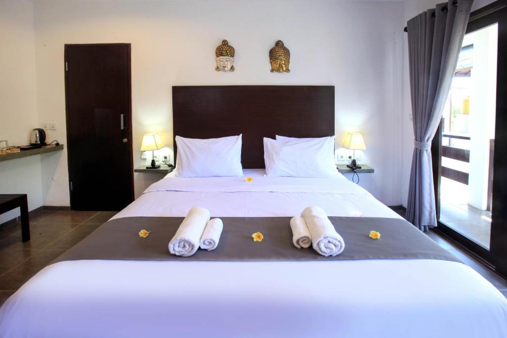 吉利特拉旺安Gili Ocean Club - ADULTS ONLY的卧室配有带毛巾的大型白色床