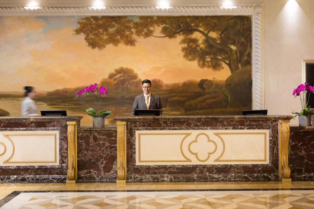 即墨青岛海泉湾皇冠假日度假酒店的站在一张桌子上画着画的房间里的人