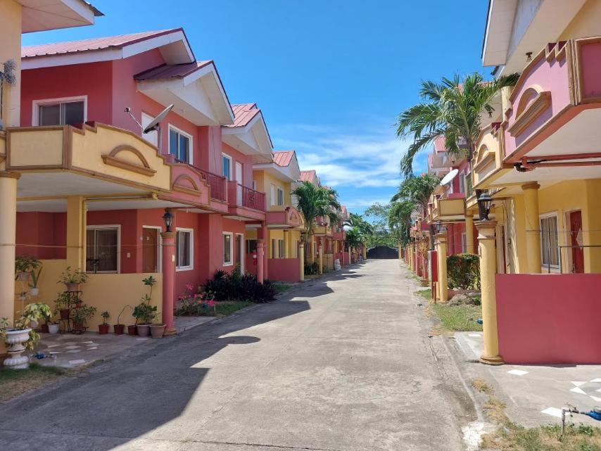 麦克坦Vacation Town House Near Mactan Cebu Airport的一条空的街道,有五颜六色的房屋和棕榈树