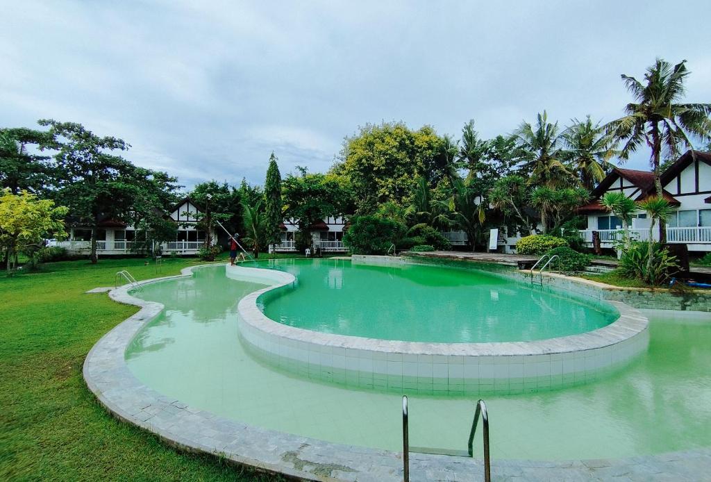 OtonRedDoorz @ Padi Beach Resort Oton Iloilo的庭院中间的大型游泳池