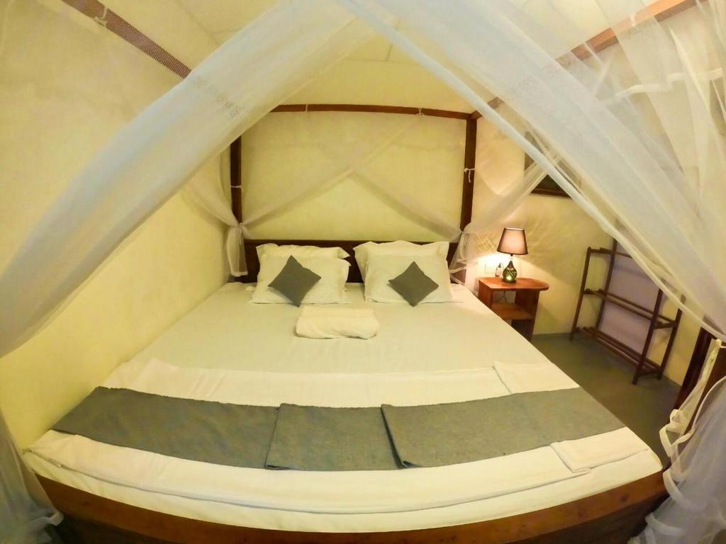 阿杭格默Ostello Surf Resort的一间卧室配有一张带天蓬的白色床