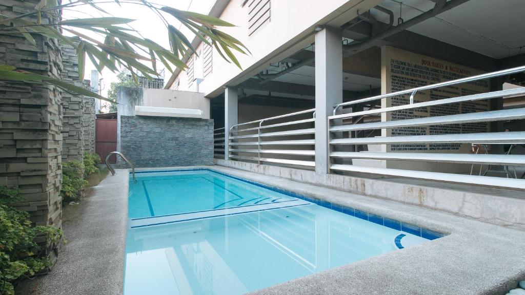 宿务RedDoorz at Grand Apartelle Hernan Cortes Cebu的建筑物一侧的游泳池