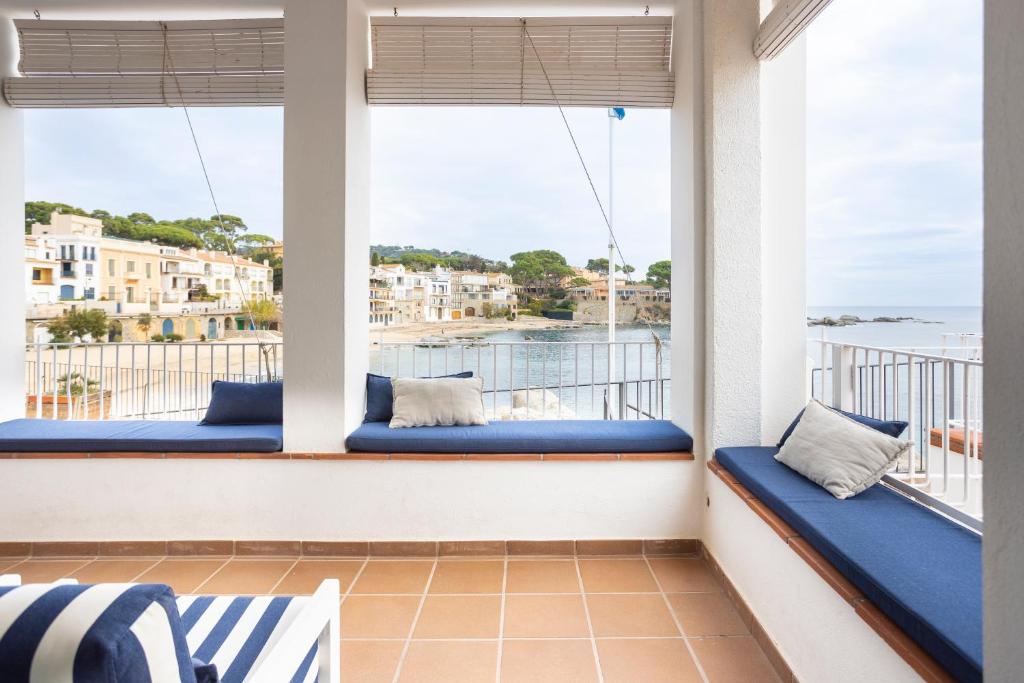 卡莱利亚德帕拉弗鲁赫尔CASA SOL I PLATJA Calella Palafrugell con Parking的阳台设有蓝色靠垫,享有海景。