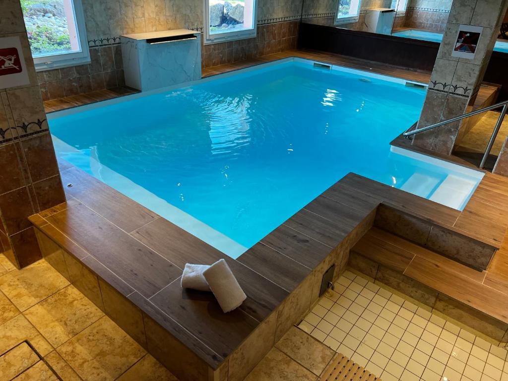 利克维希克维尔酒店的大型游泳池周围设有木凳