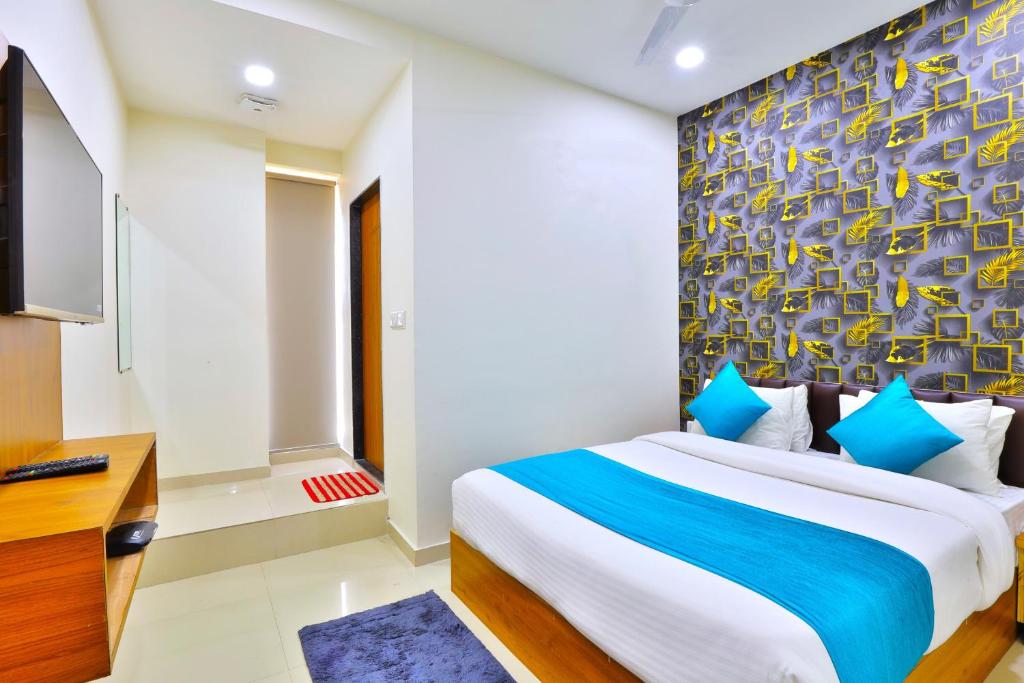 艾哈迈达巴德Hotel Shivaay的一间带大床和电视的卧室