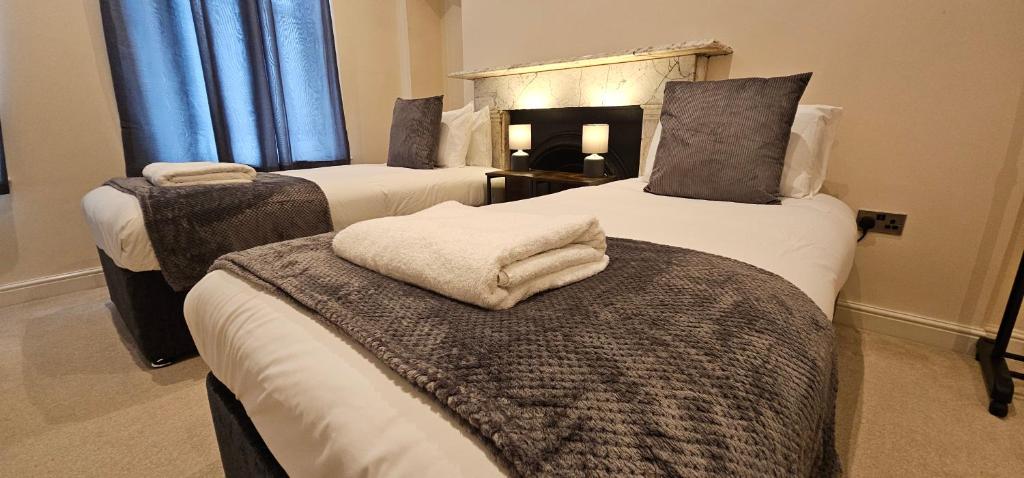 伊普斯威奇Modern 2 bedrooms apartment in Town centre的一间设有三张床的客房,备有毛巾