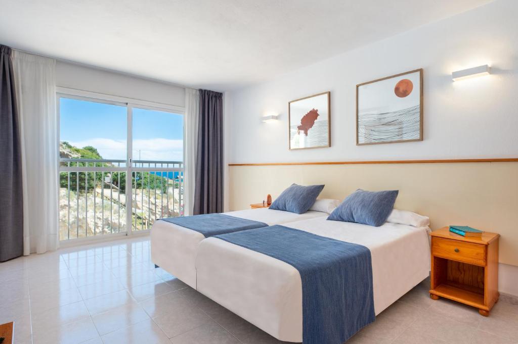 伊维萨镇Apartamentos Vibra Tropical Garden的一间卧室设有一张床和一个大窗户