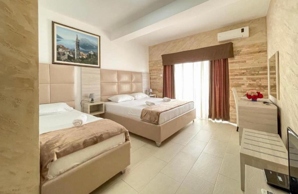 乌尔齐尼Imperial Hotel的酒店客房设有两张床和窗户。