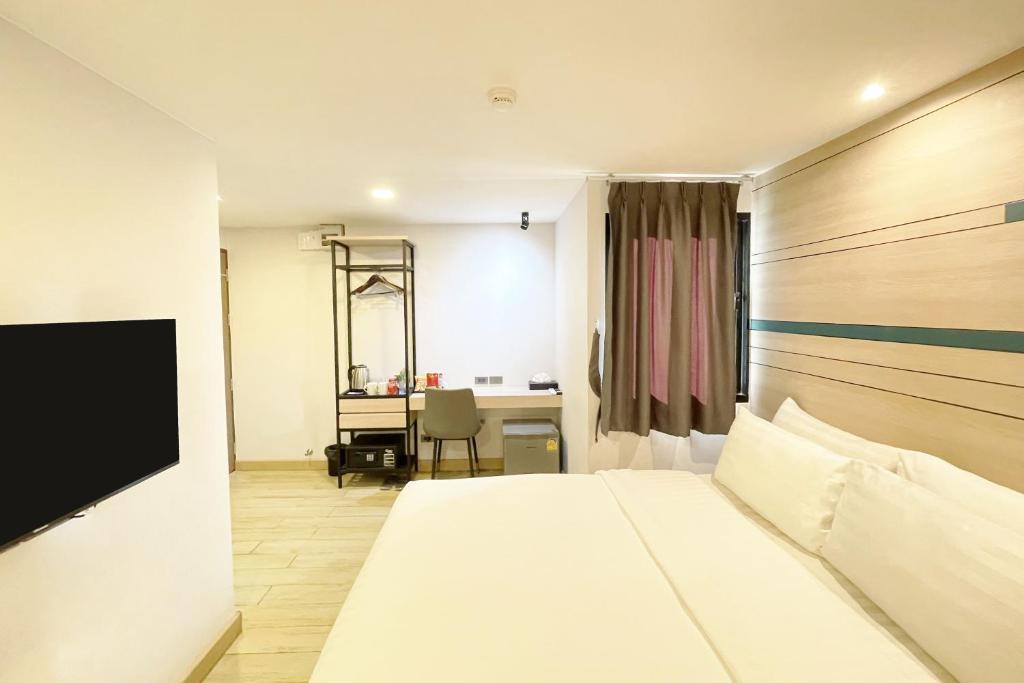 曼谷City Park Hotel Bangkok Pratunam by PCL的配有一张床和一张书桌的酒店客房