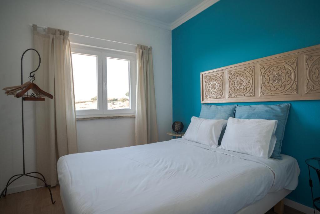 埃里塞拉Casa da Ribeira Quarto Turquesa的一间卧室设有一张蓝色墙壁的大床