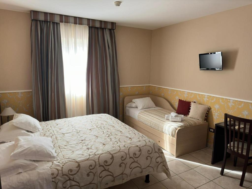 菲乌米奇诺瑞莱别墅酒店的酒店客房设有两张床和窗户。