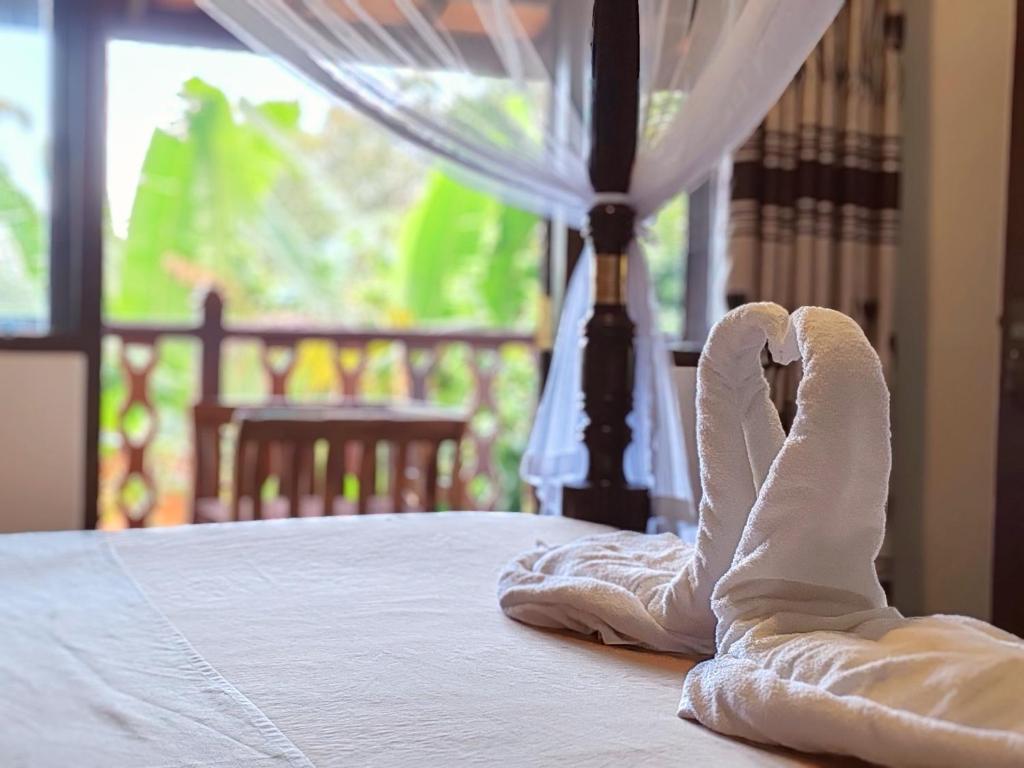 米瑞莎The Jungle View的床上一双脚的白色毛巾