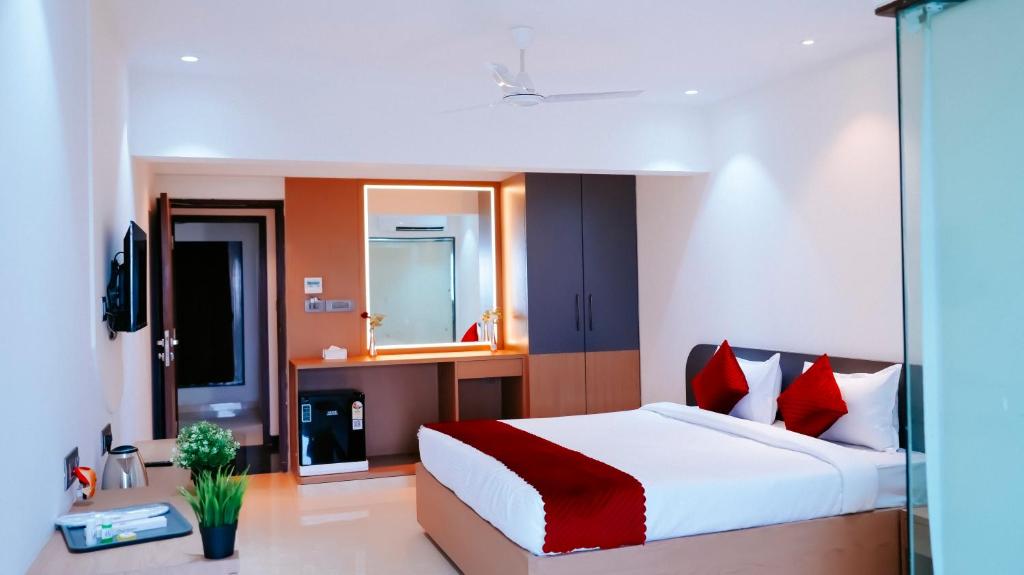 孟买Hsquare Hotel Andheri West的一间卧室配有一张带红色枕头的大床