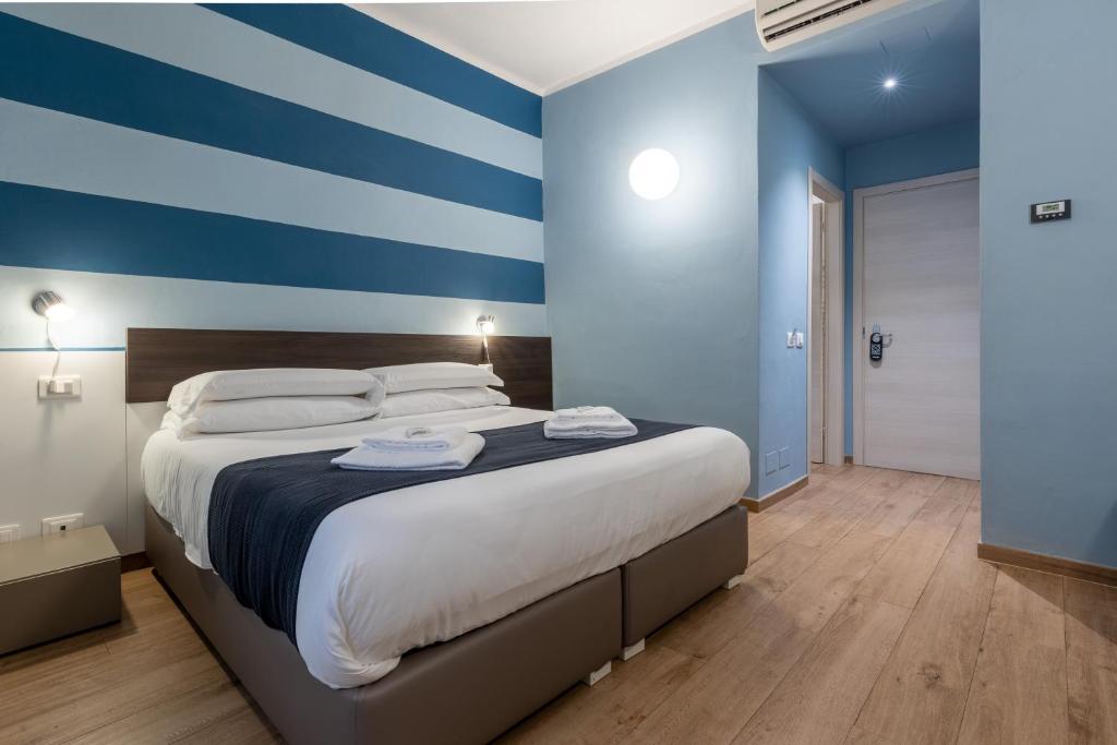 斯培西亚拉洛贾德班驰旅馆的一间卧室配有一张蓝色和白色条纹的大床