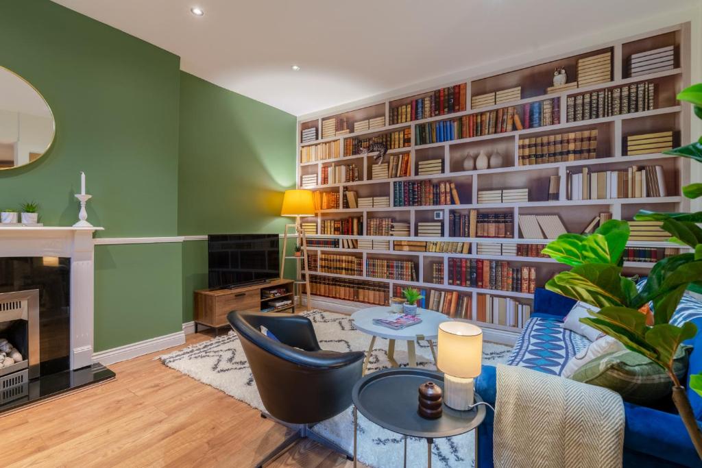 切尔滕纳姆Regency Basement Apartment的客厅拥有绿色的墙壁和大型书架