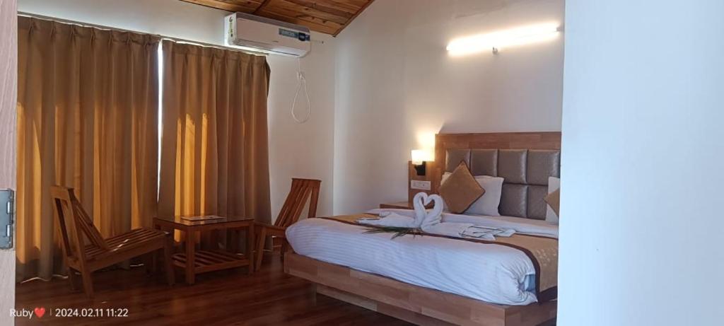 BelparāoJim Corbett Tiger Resort的一间卧室配有一张床、一张书桌和一个窗户。