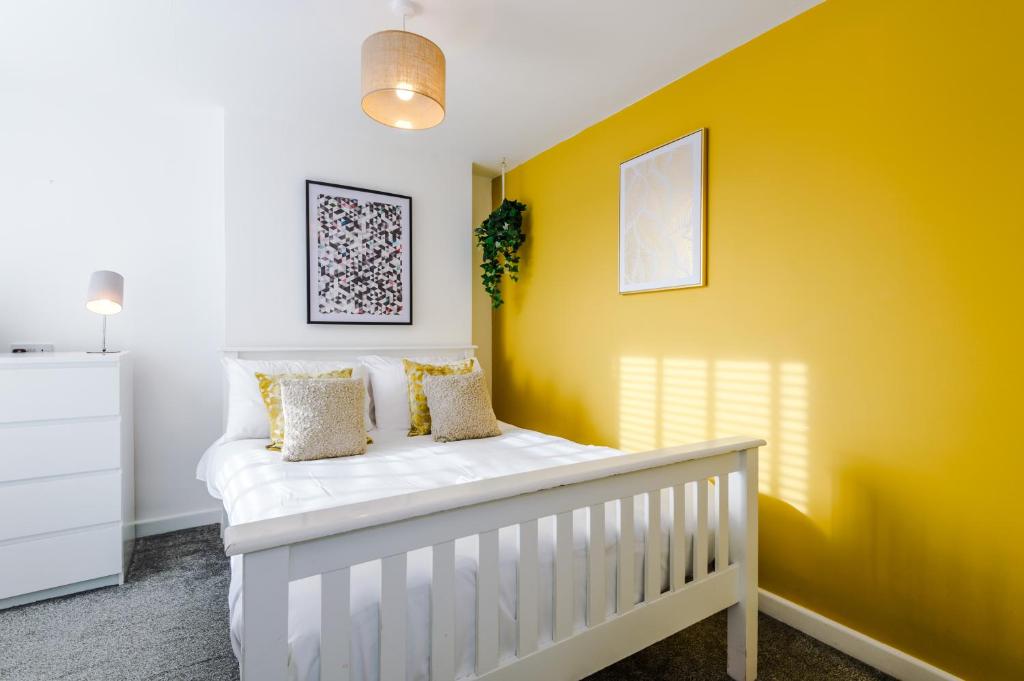 切斯特Large 7 bedroom town house in Chester City Centre的黄色墙壁的房间里一张白色的婴儿床