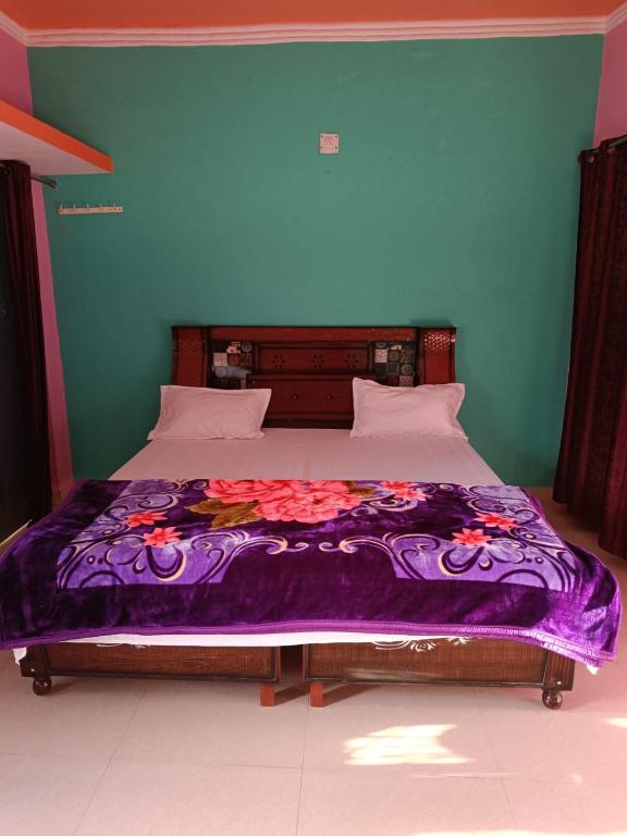 Barkotgaurav home stay的床上有紫色毯子