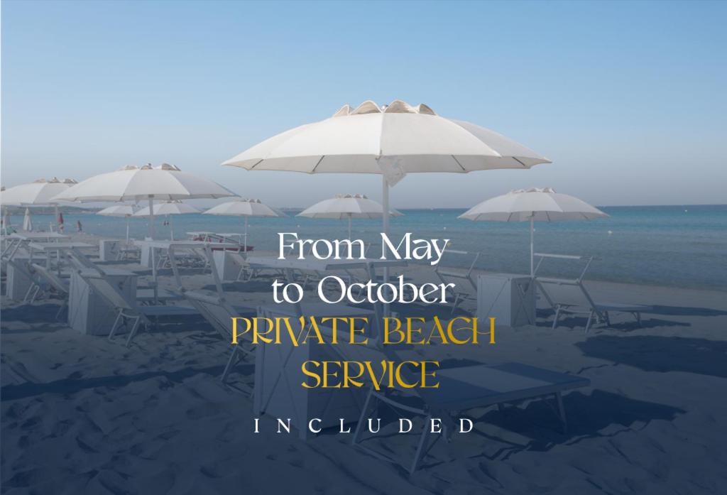 加利波利布拉达海岸大酒店的沙滩上设有桌子和遮阳伞