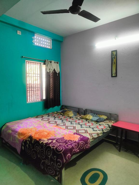 普里jharana guest house的一间带一张床铺的卧室,位于带天花板的房间内