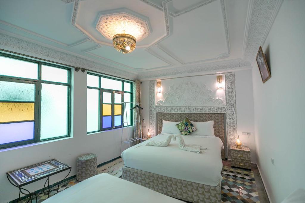 非斯Riad dar Yamna的一间卧室设有两张床和天花板