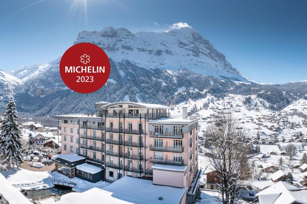 格林德尔瓦尔德瑞士丽城优质酒店的雪中酒店,背景是一座山